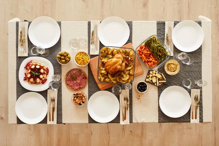 High angle view of served table with roast turkey in the middle of the table and other dishes ready...