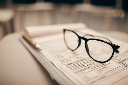 Close-up of business contract with eyeglasses on the table at officeの写真素材