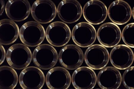 Close-up of large number of new metal pipes in a row in the metal factoryの写真素材
