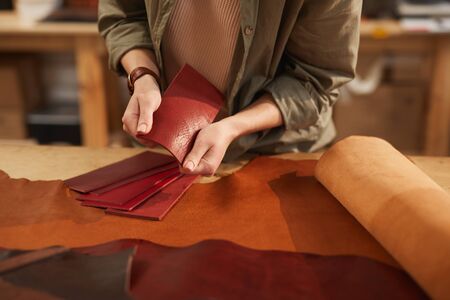 Horizontal shot of unrecognizable young woman choosing best leather material for her new craftwork
