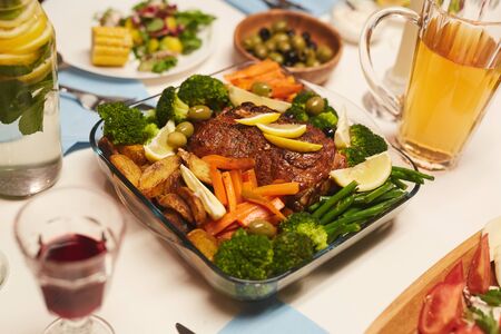 Image of roast meat with potatoes and vegetables served for dinner on the tableの写真素材