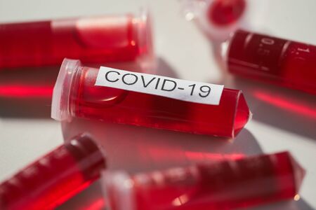 Close-up of capsules with red liquid from disease covid-19 on the tableの写真素材