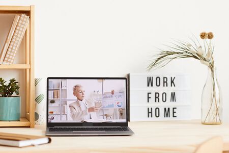 Mature businesswoman holding financial graphics and holding business presentation online from monitor of laptopの写真素材