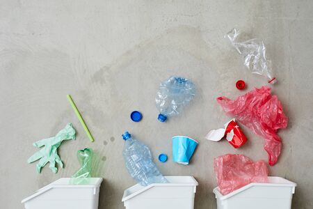 Image of three trash bins with sorted garbage isolated on grey backgroundの写真素材