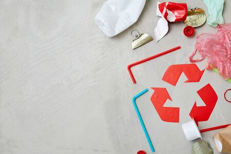 Close-up of red recycling symbol with waste isolated on grey backgroundの写真素材