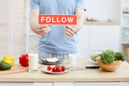 Close-up of blogger holding placard Follow in his hands he leading the blog about healthy foodの写真素材