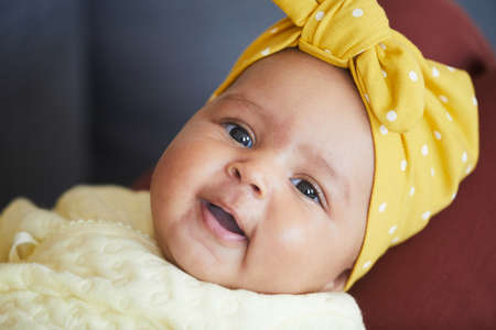 Portrait of cute baby girl with bow on her head looking at cameraの写真素材