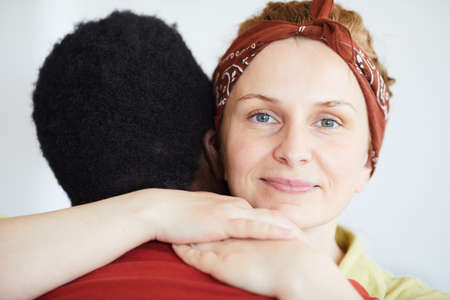 Portrait of young woman looking at camera while embracing the manの写真素材
