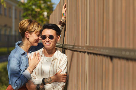 Portrait of young stylish lesbians standing outdoors in summer day and smilingの写真素材