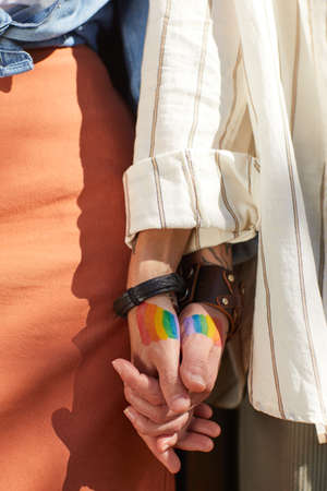 Close-up of female couple standing outdoors and holding hands