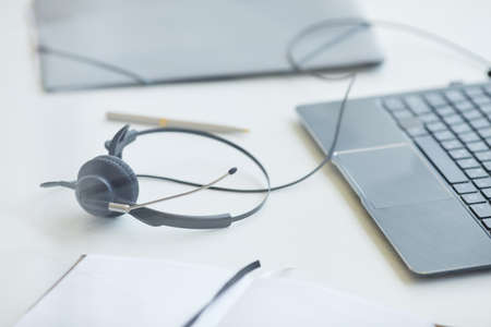 Close-up of headphones with laptop on the table the working day is overの写真素材