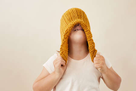 Little girl wearing warm wool hat on her head against the white background
