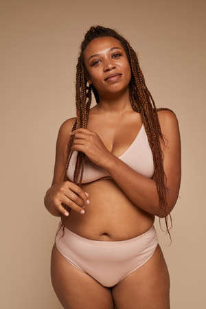 Portrait of beautiful overweight woman with stylish hairstyle looking at camera against the white backgroundの写真素材