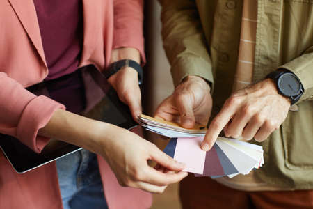 Close-up of business people pointing at patterns and choosing the color for future projectの写真素材