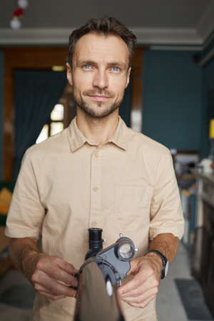 Portrait of young astronomer looking at camera while using his telescope to watch for the stars
