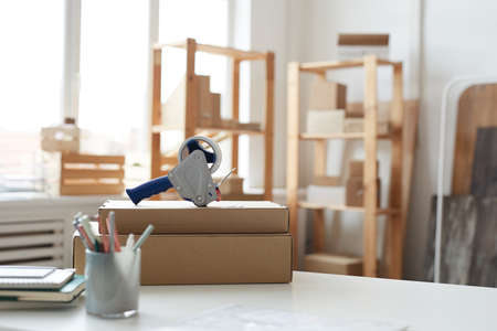 Image of table with packed cardboard boxes with adhesive tape on them in warehouse