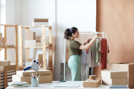Workplace with packed cardboard boxes with woman working in warehouseの写真素材