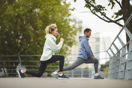 Young couple doing exercises together during sports training in the park
