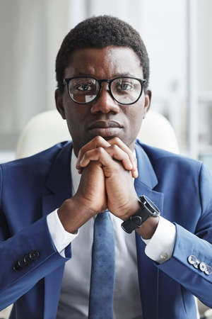 Portrait of African businessman in eyeglasses and in formalwear looking at camera