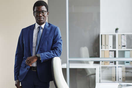 Portrait of African businessman in formalwear looking at camera while working at officeの写真素材