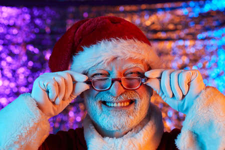Close-up of bearded man in Santa hat wearing glasses and smiling at cameraの写真素材