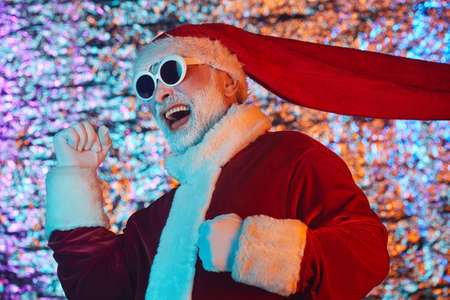 Excited Santa Claus in sunglasses having fun during party