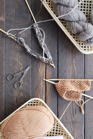 High angle view of baskets with balls of yarn and other sewing items on wooden table