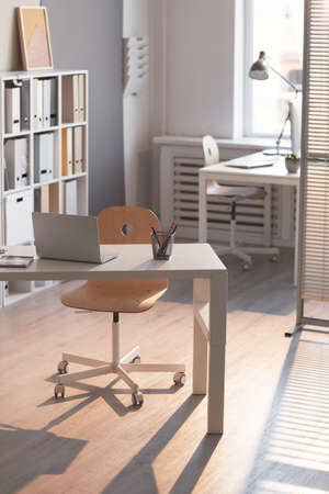 Image of empty room at office with desk with laptop on it