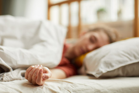 Close-up of young woman lying on bed and sleeping at homeの写真素材