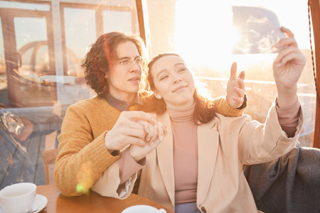 Young family looking at ultrasound image of their baby while sitting in cafe