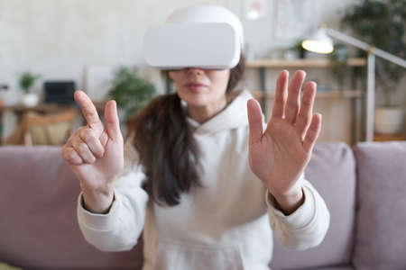Woman gesturing during game on sofa at home