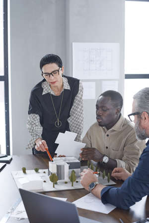 Group of engineers developing new project of building at the table during business meeting at office
