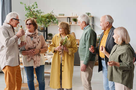 Group of senior people gathering together on social event they standing and talking to each otherの写真素材