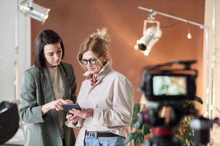 Business people watching something on digital tablet while working in recording studioの写真素材