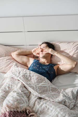 Transsexual lying in his bed and waking up in the morning in his bedroom