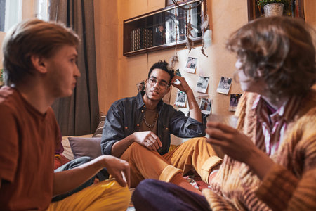 Group of friends talking to each other while sitting in the room at home