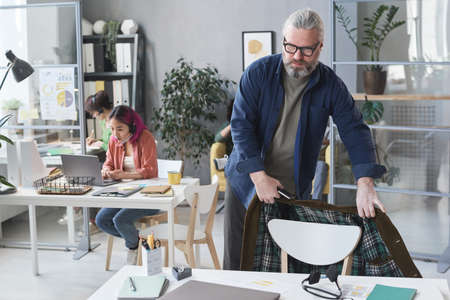 Mature businessman finishing his work at office and going homeの写真素材