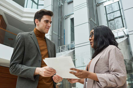 Young business people discussing business contract together while standing in the city