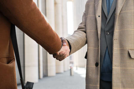 Close-up of business people shaking hands at meeting at the city
