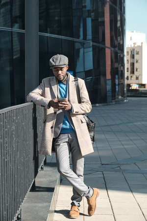 African businessman using smart phone while standing in the cityの写真素材