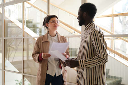 Two business partners discussing business contract in team while working at office
