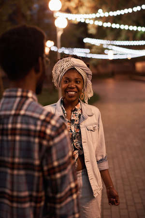 African young couple walking together in the evening in the parkの写真素材