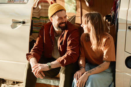 Young couple sitting in the bus and talking to each other they spending time outdoorsの写真素材