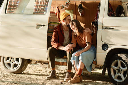 Young couple sitting in the van and embracing each other they enjoying their vacationsの写真素材
