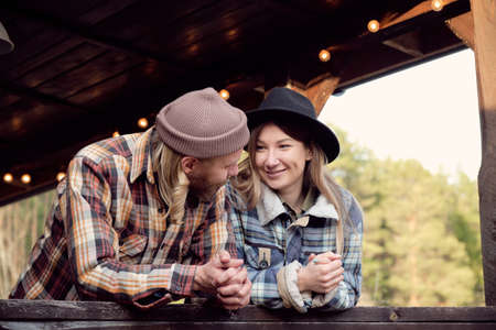 Young couple of farmers talking to each other while standing on terrace in the countryの写真素材