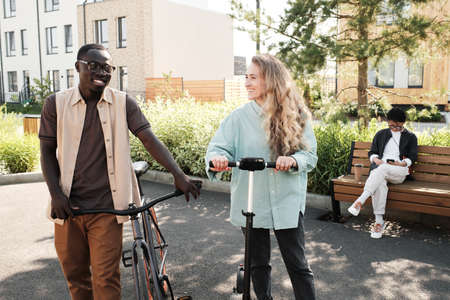 Horizontal medium long shot of young African American man and his Caucasian girlfriend walking...