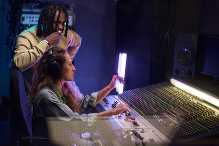 Composer and singer working on new album using electric keyboard in the recording studio