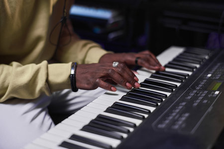 Close-up of African musician playing electric piano in the music studioの写真素材