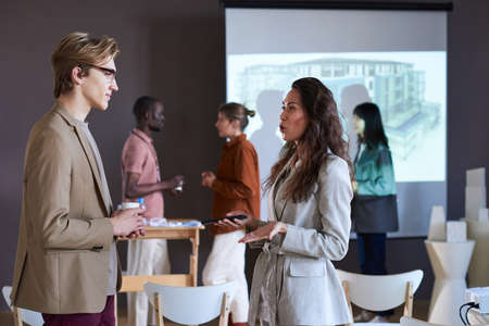 Businesswoman talking to businessman during a break at the seminarの写真素材