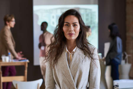 Portrait of young businesswoman in elegant suit looking at camera while visiting seminarの写真素材